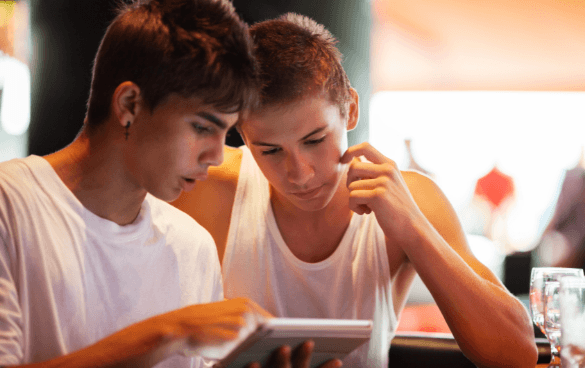 Two men browsing on a tablet together