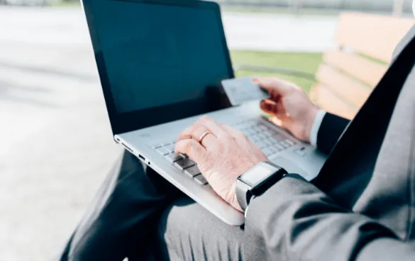 Homem de negócios fazendo compras em um laptop com cartão de crédito