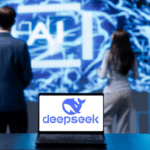 Duas pessoas olhando tela com os dizeres AI com um cérebro desenhado em led atrás. Em primeiro plano, computador com logo da IA chinesa DeepSeek na tela