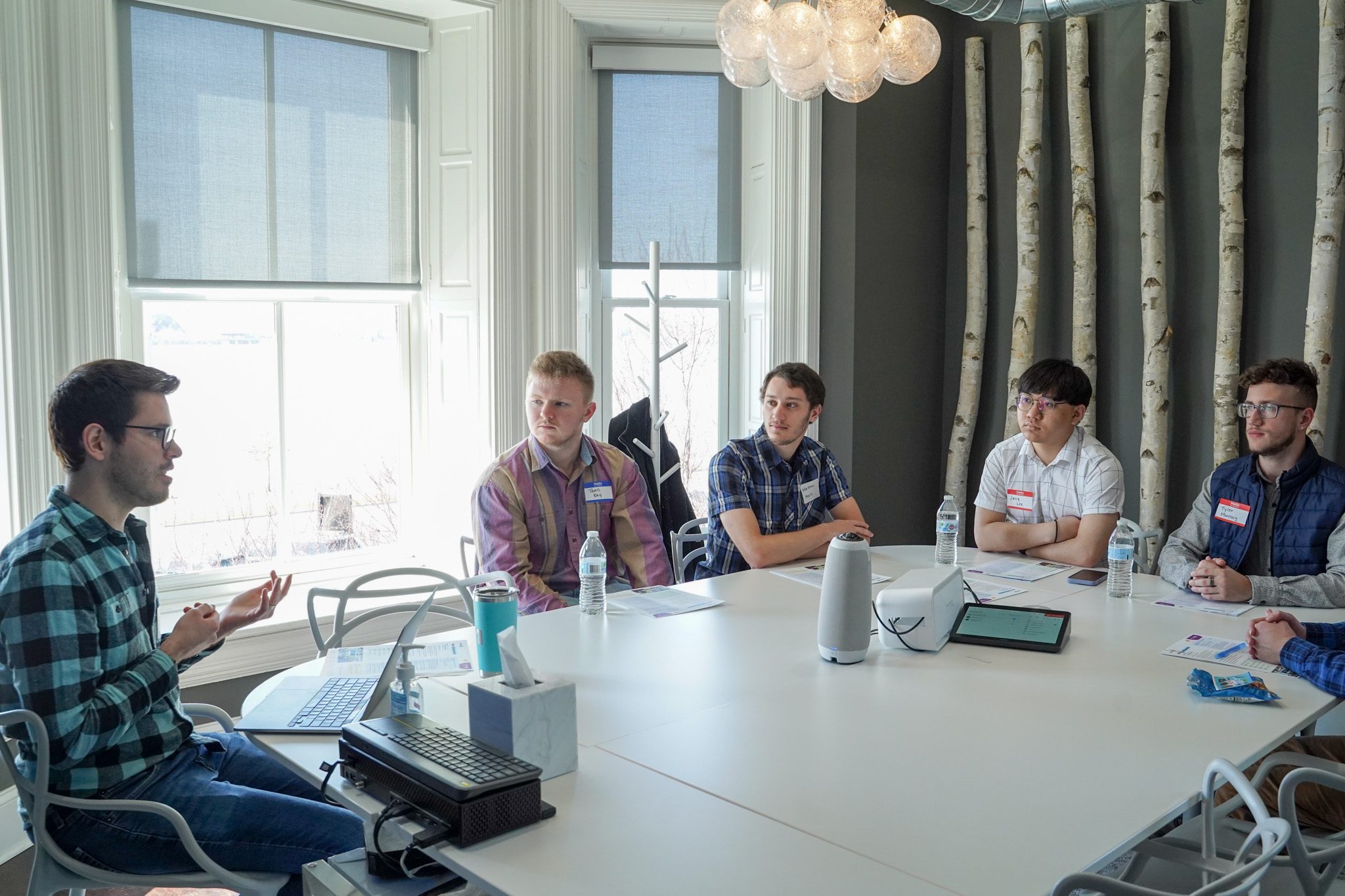 Andrew apresentando-se a um grupo de pessoas em vestido casual de negócios