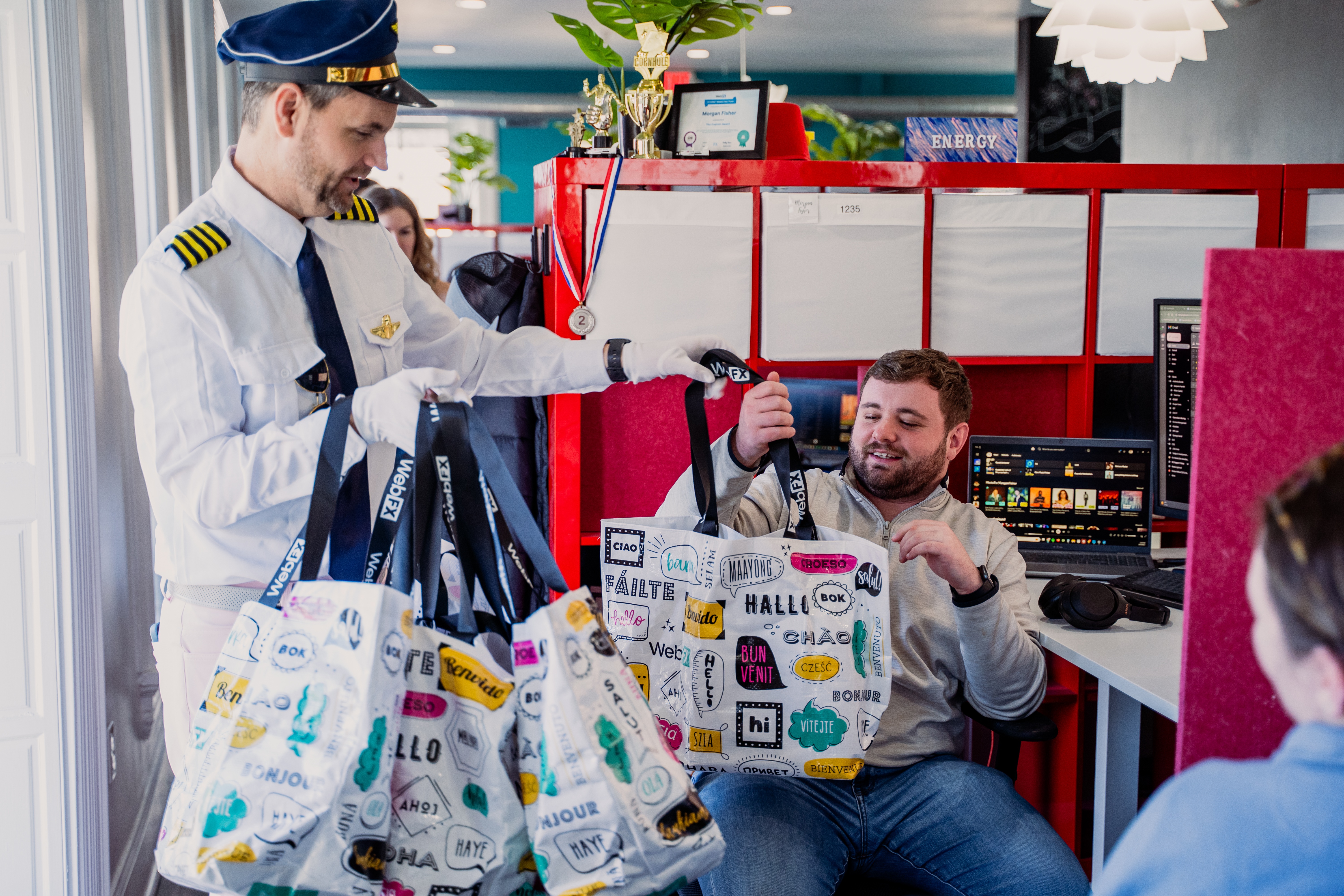 Bill, presidente da Webfx, distribuindo sacos de ganhos a um membro da equipe