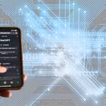 Fotomontagem que mostra uma mão segurando um celular sobre um fundo em tons azuis reproduzindo circuitos eletrônicos