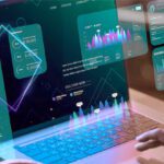 Tela de um notebook com vários dados, números, gráficos e itens saindo da tela